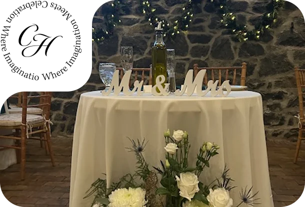 Sweetheart table at Rockwood Carriage House with Mr. and Mrs. sign, white floral arrangement, and stone wall backdrop